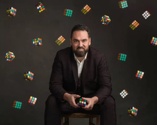 Portrait crÃ©atif du magicien Harry Covert entourÃ© de Rubikâs Cubes