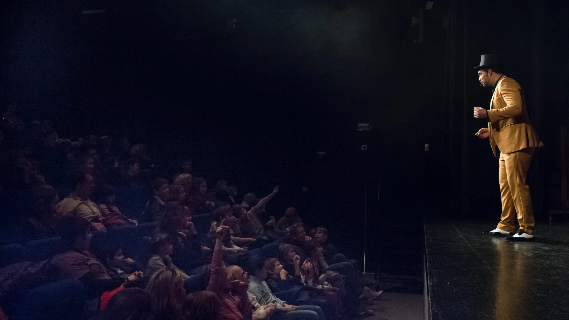 Harry Covert interacts with the audience during a family magic show in a theatre