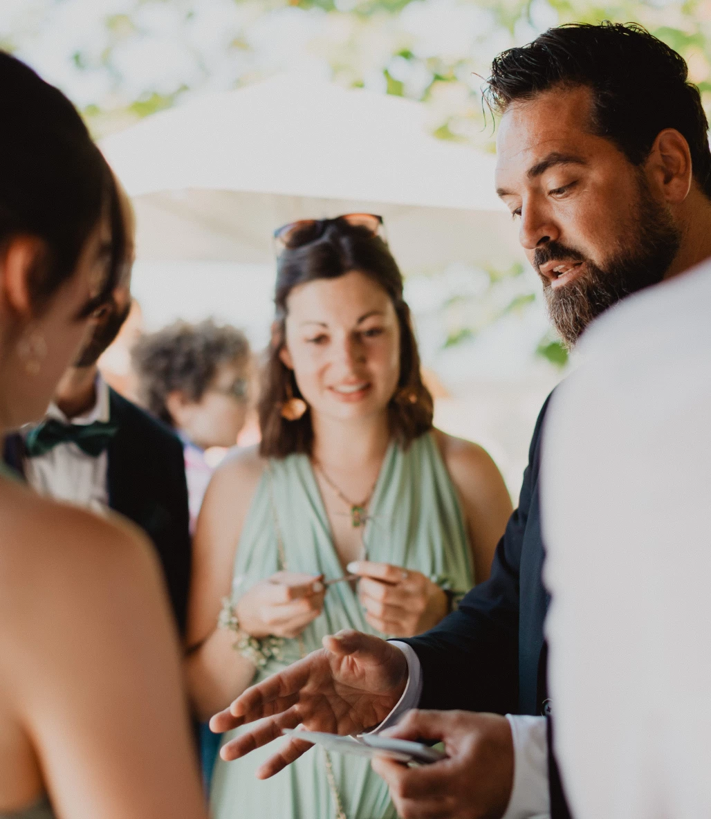 Harry Covert présente un tour de magie close-up à des invités pendant un cocktail de mariage